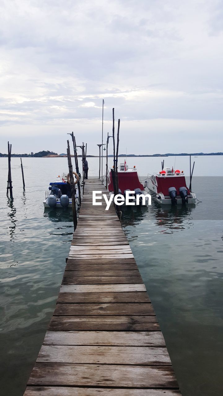 WOODEN PIER ON SEA AGAINST SKY