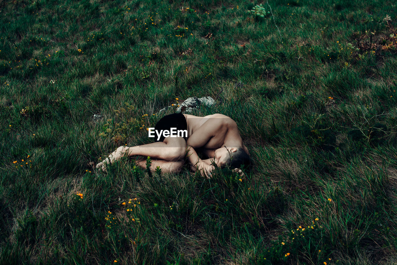 HIGH ANGLE VIEW OF WOMAN LYING ON GRASS