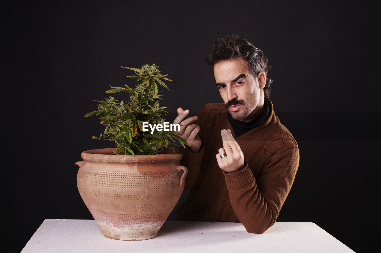 one person, adult, men, studio shot, plant, black background, indoors, potted plant, houseplant, portrait, flowerpot, growth, beard, nature, facial hair, copy space, lifestyles, business, dark, looking, person