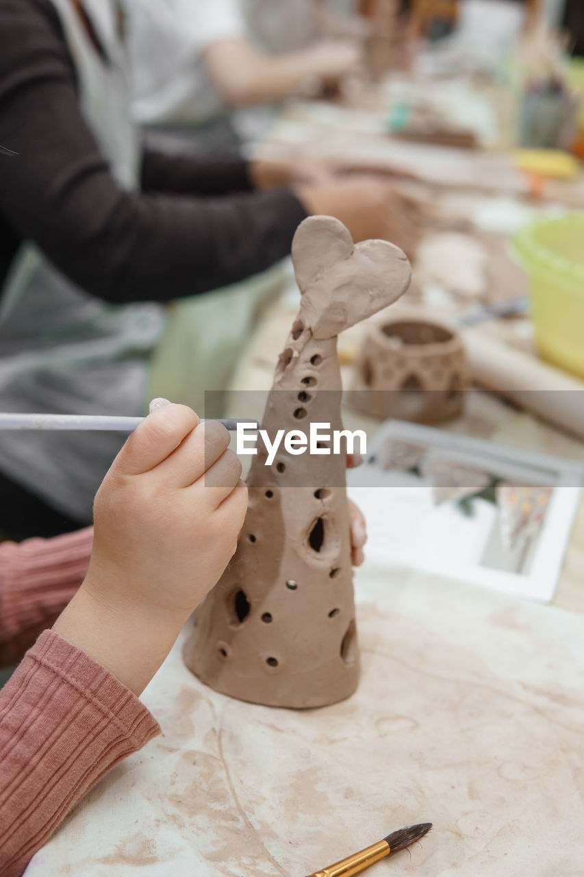 Women's hands knead clay, drawing elements of the product. production of ceramic products. 