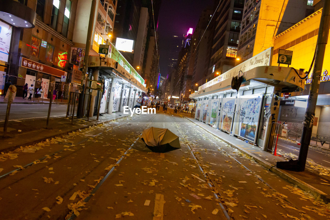 Illuminated street amidst buildings in city at night