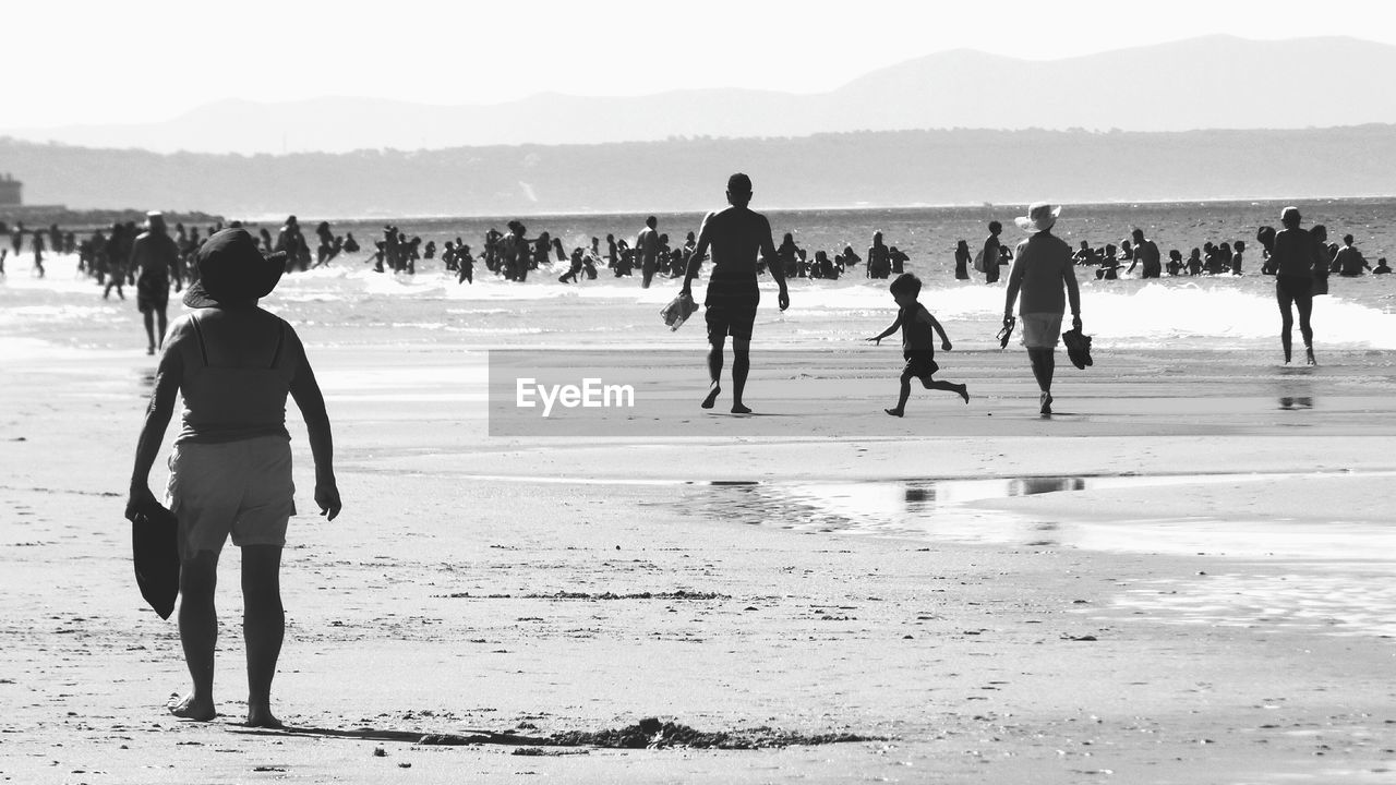 PEOPLE AT BEACH AGAINST SKY