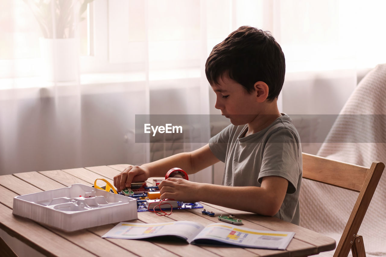Child boy collects electronic constructor. educational toys. development of preschool children