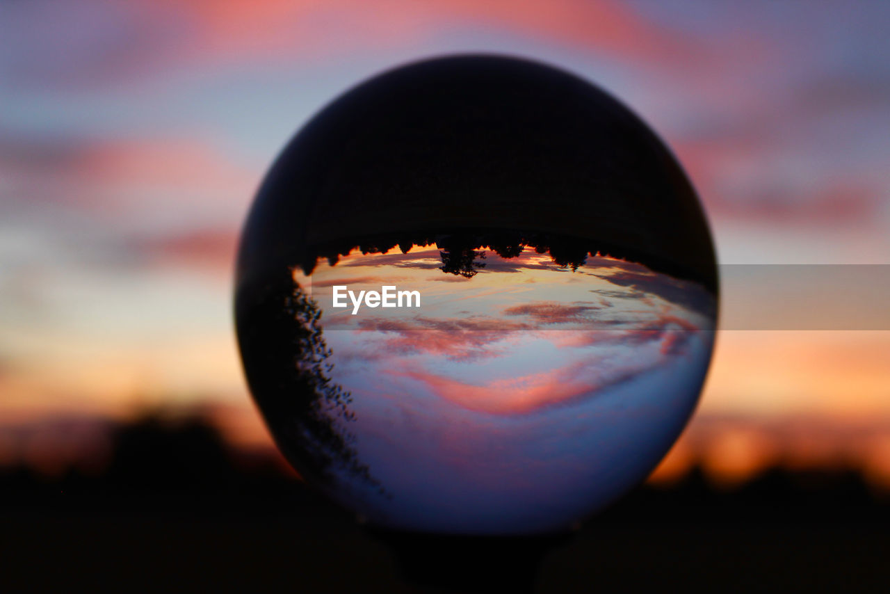 Close-up of crystal ball against sunset