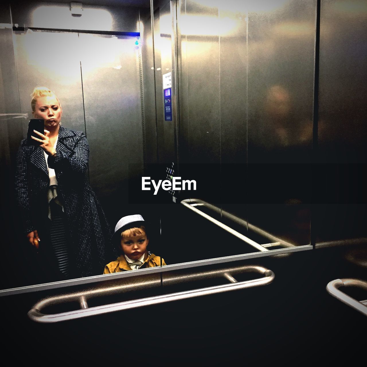 Self portrait of woman and child in elevator