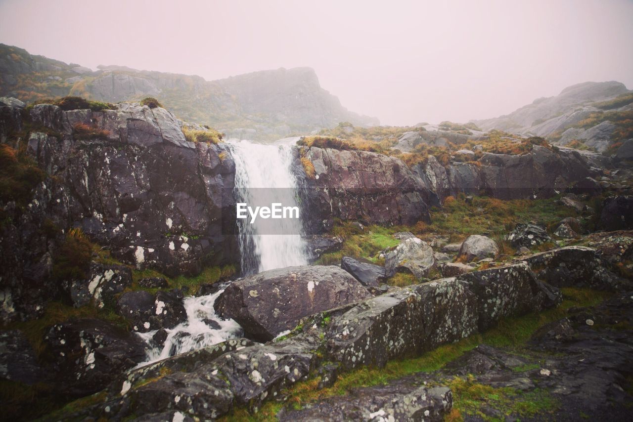 Scenic view of waterfall against sky