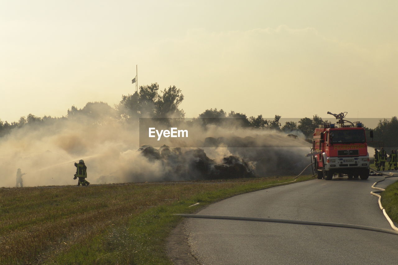 PANORAMIC VIEW OF PEOPLE ON ROAD AMIDST FIELD