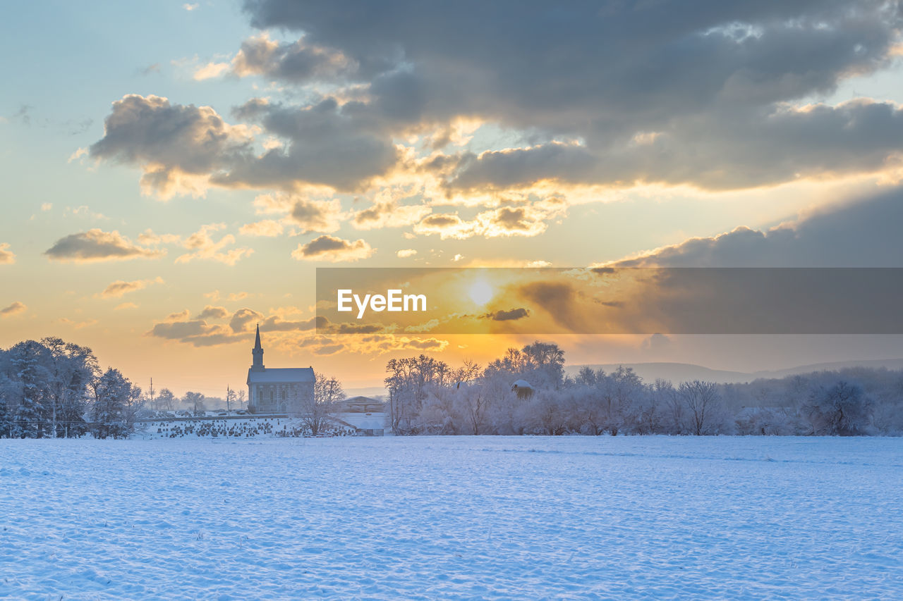 Scenic view of snow field against sky during sunset