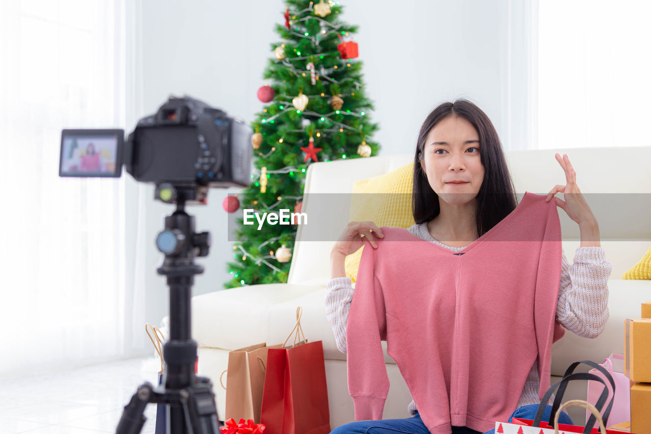 Blogger showing clothes while filming at home during christmas