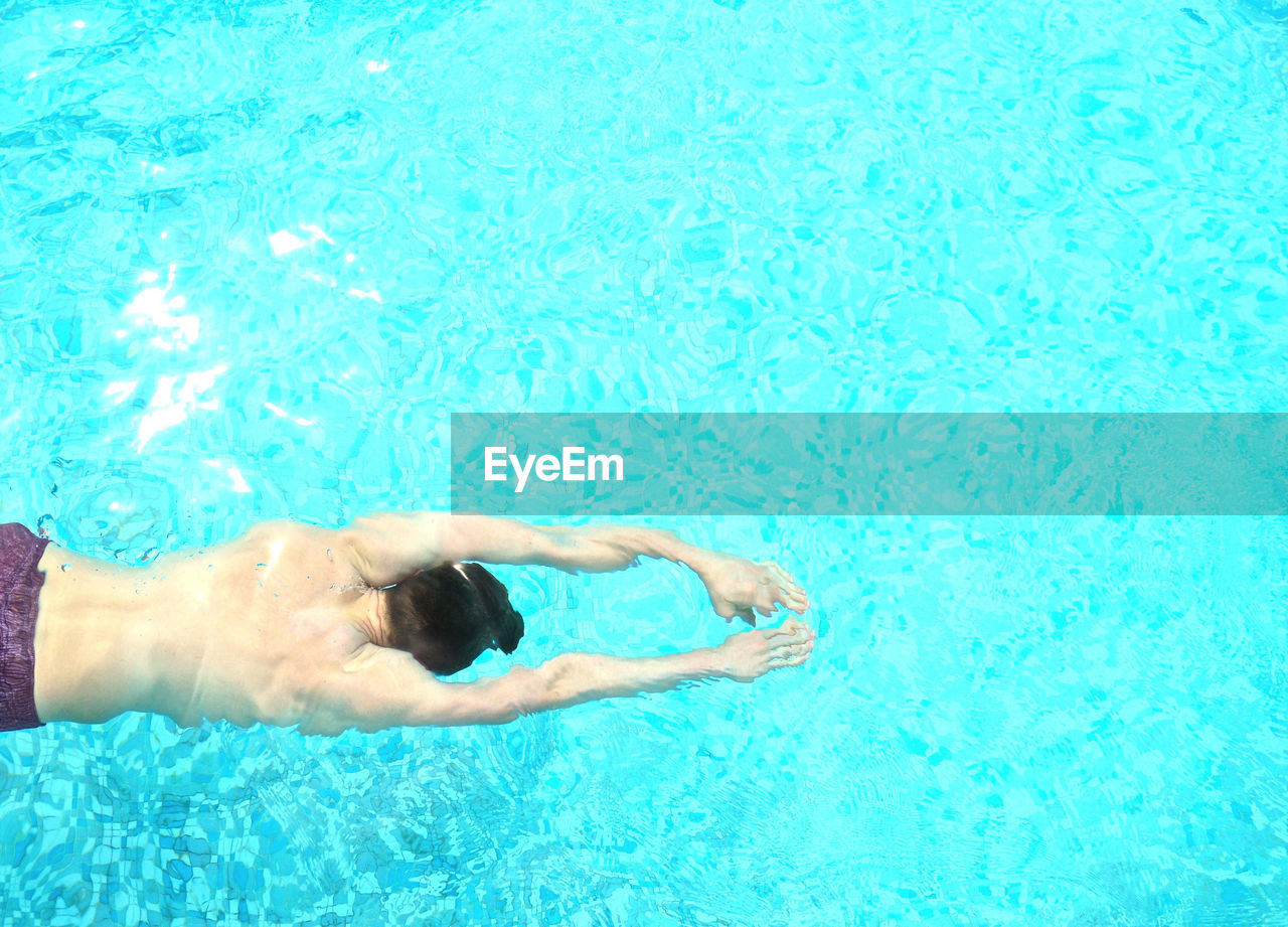 Directly above shot of shirtless man swimming in pool