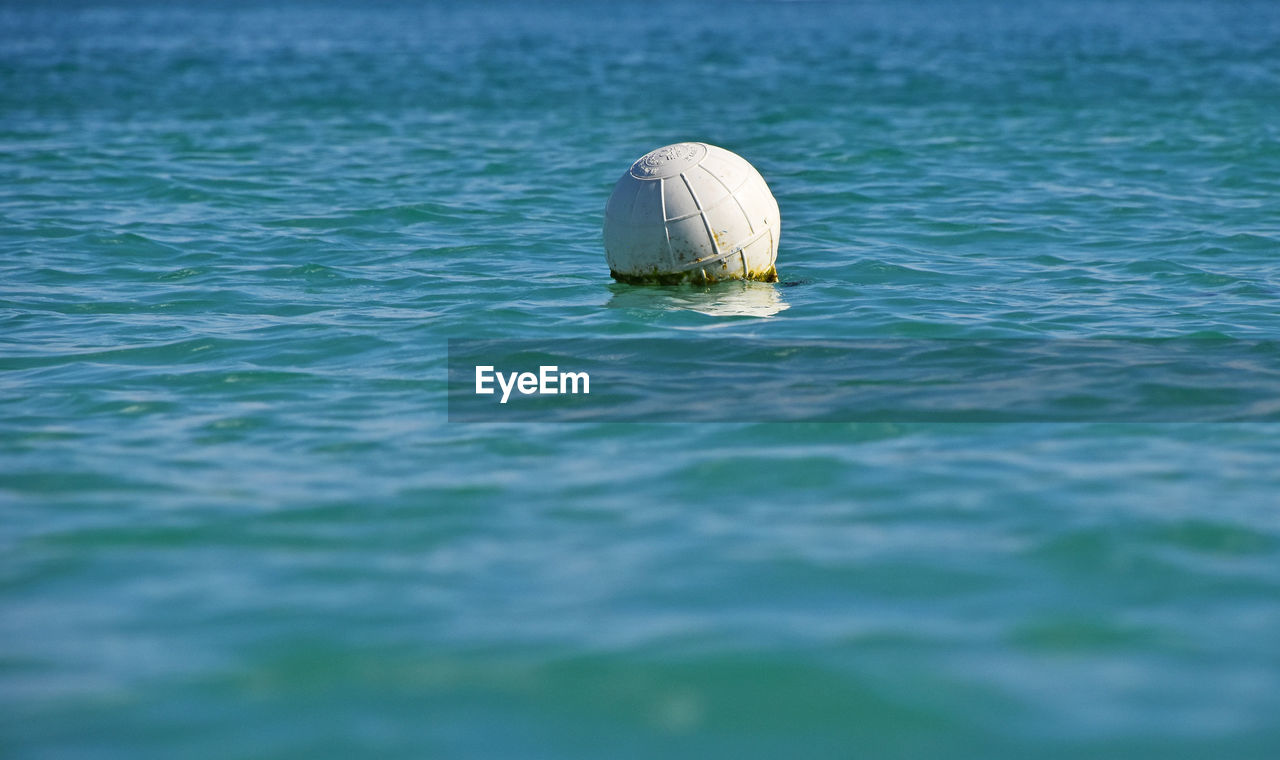 Surface level of buoy in blue rippled water