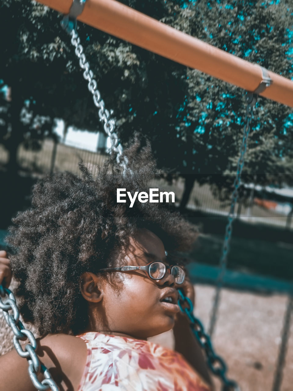 Close-up of girl swinging at park