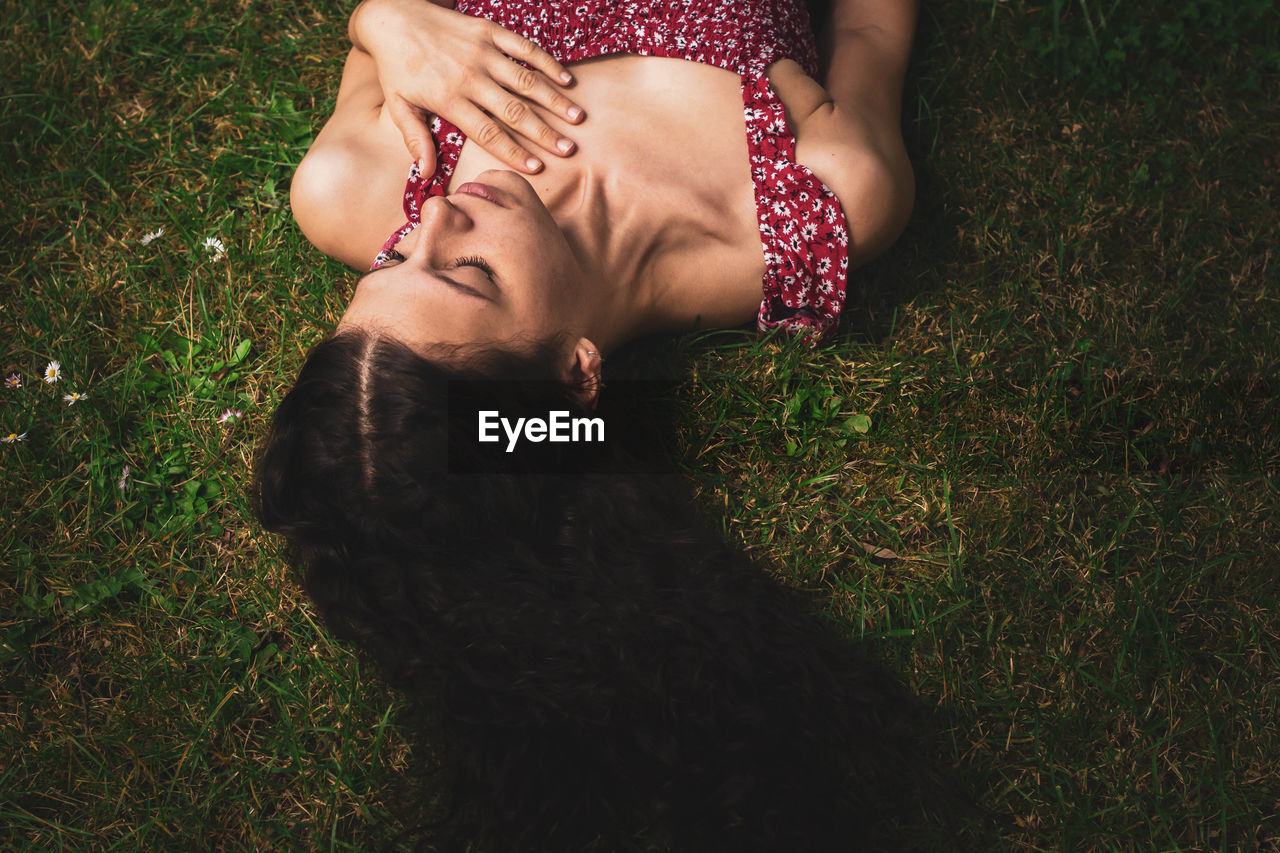 Young woman lying on grass with long straight hair