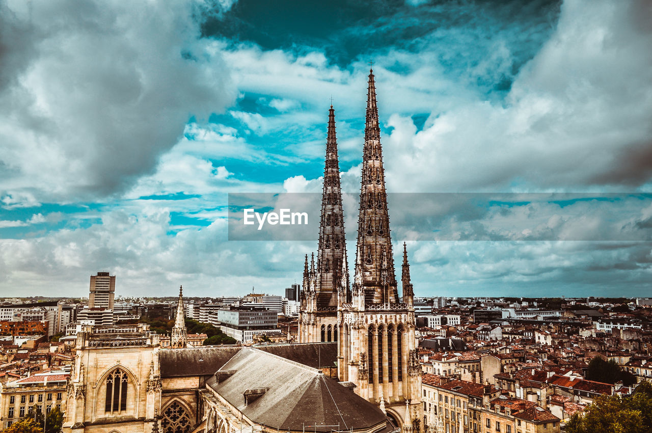 Aerial view of buildings against cloudy sky