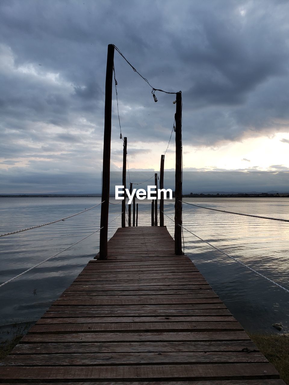 Wooden pier on sea against sky during sunset