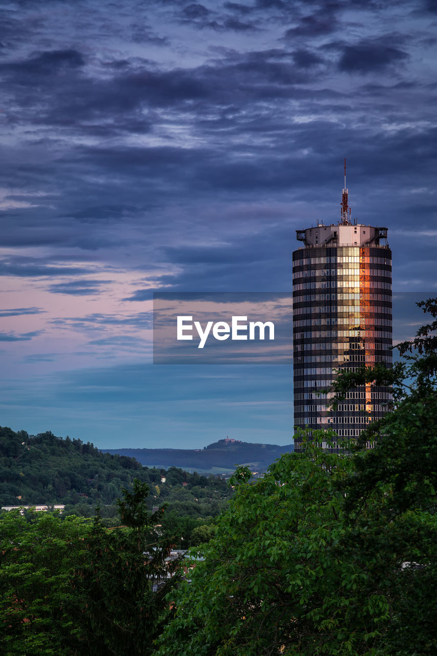 Low angle view of skyscrapers against cloudy sky