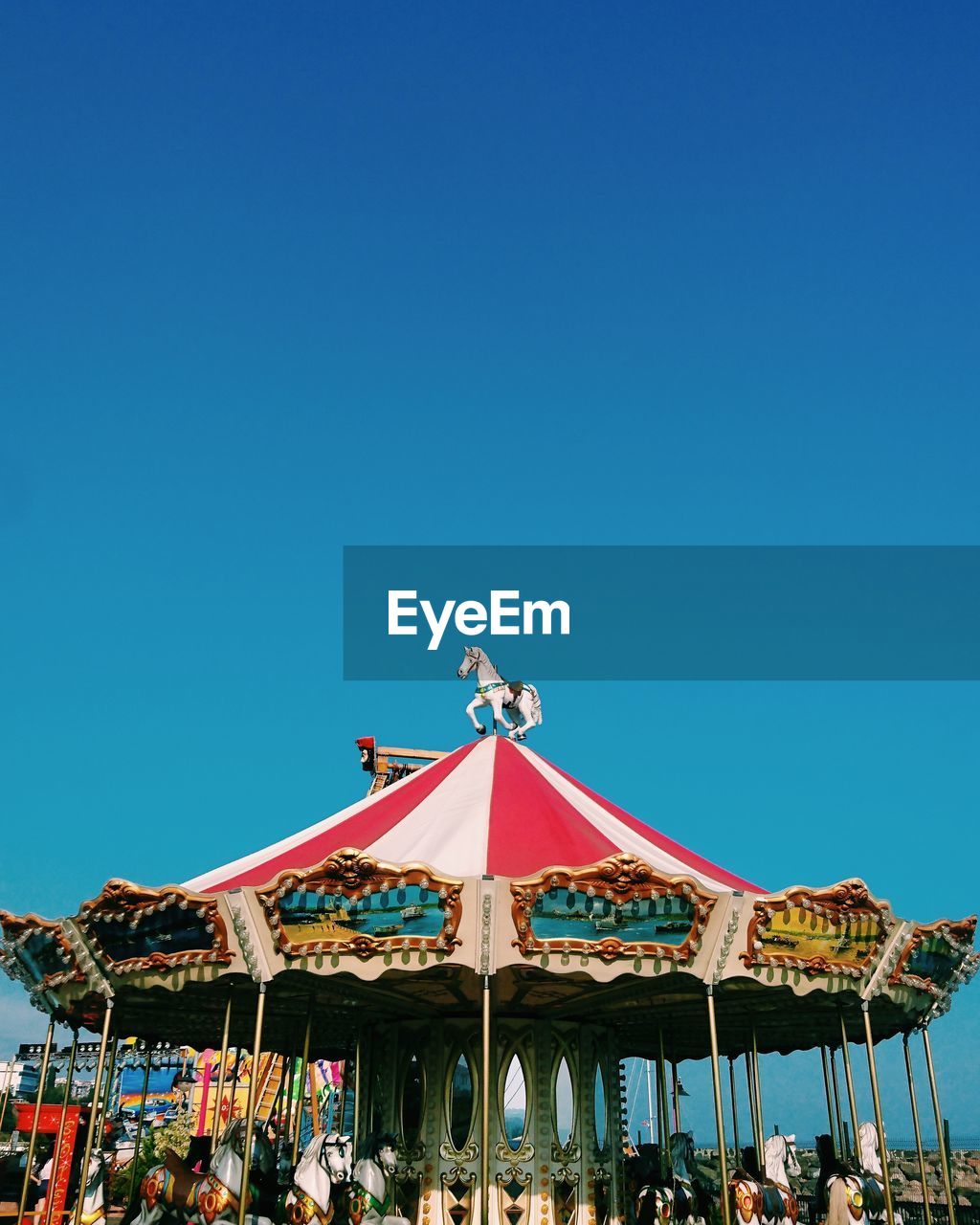 GROUP OF PEOPLE AT AMUSEMENT PARK AGAINST CLEAR BLUE SKY