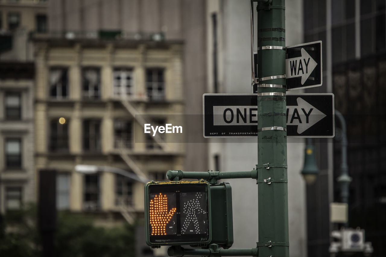 Close-up of road sign against buildings in city