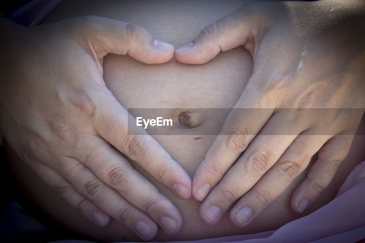 CLOSE-UP OF HAND HOLDING BABY