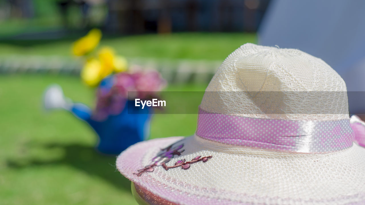 CLOSE-UP OF PURPLE HAT ON GRASS