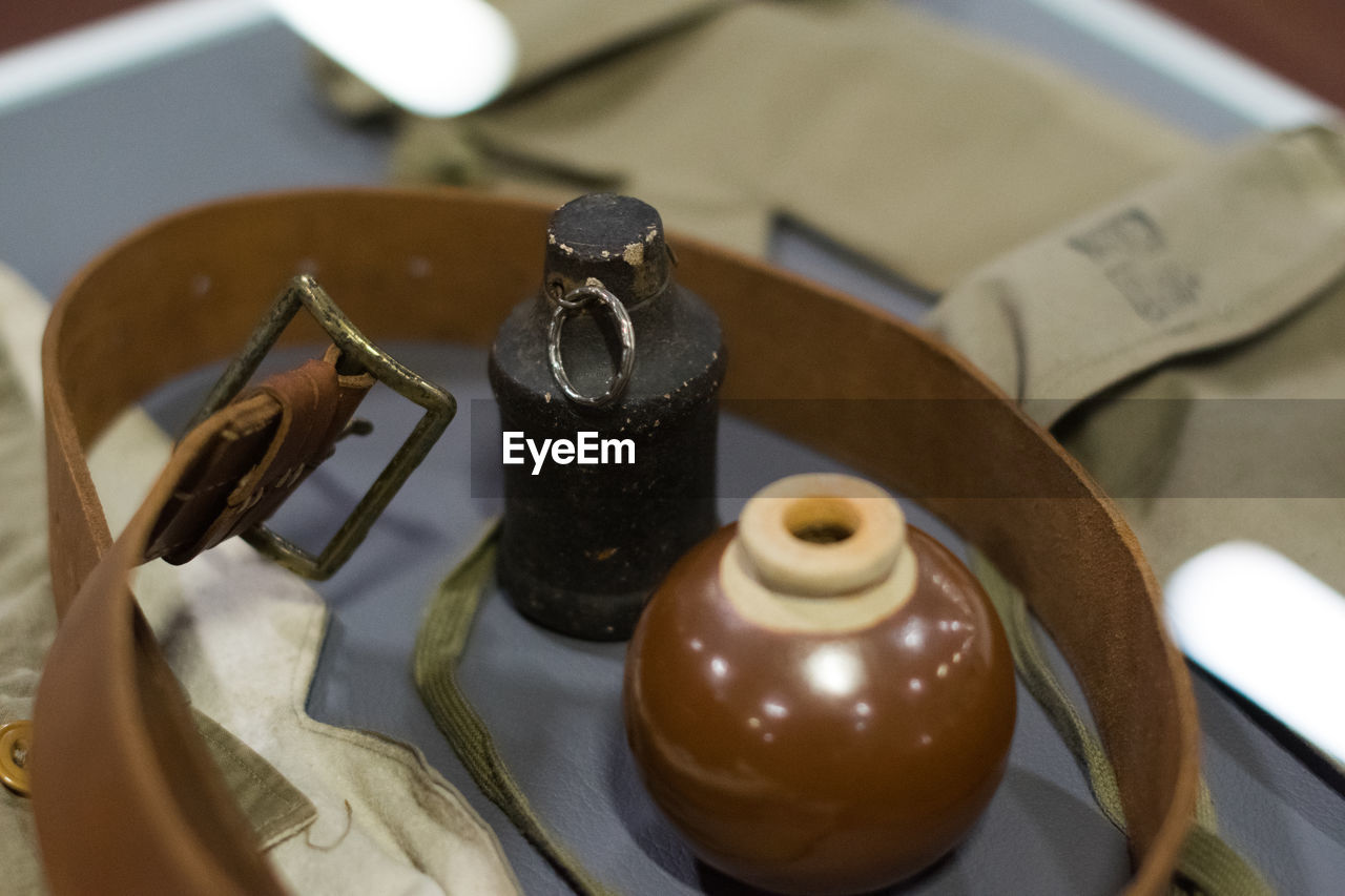 Close-up of bottles by belt on table