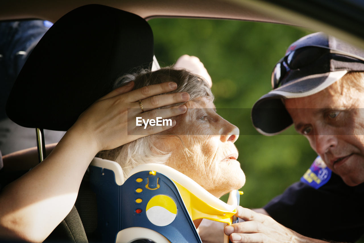 Close-up of paramedic putting neck brace on patient in car