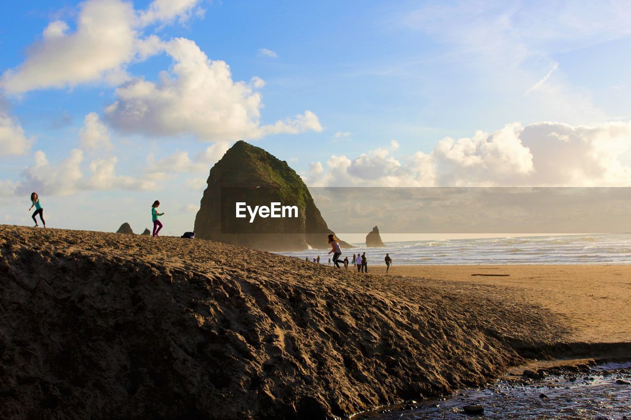 People at beach against sky