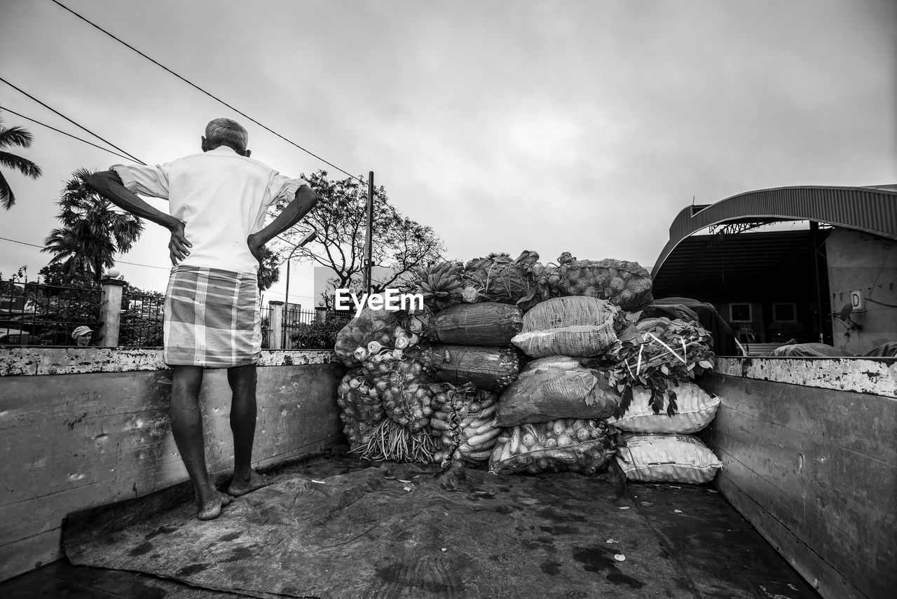 MAN STANDING BY BUILT STRUCTURE