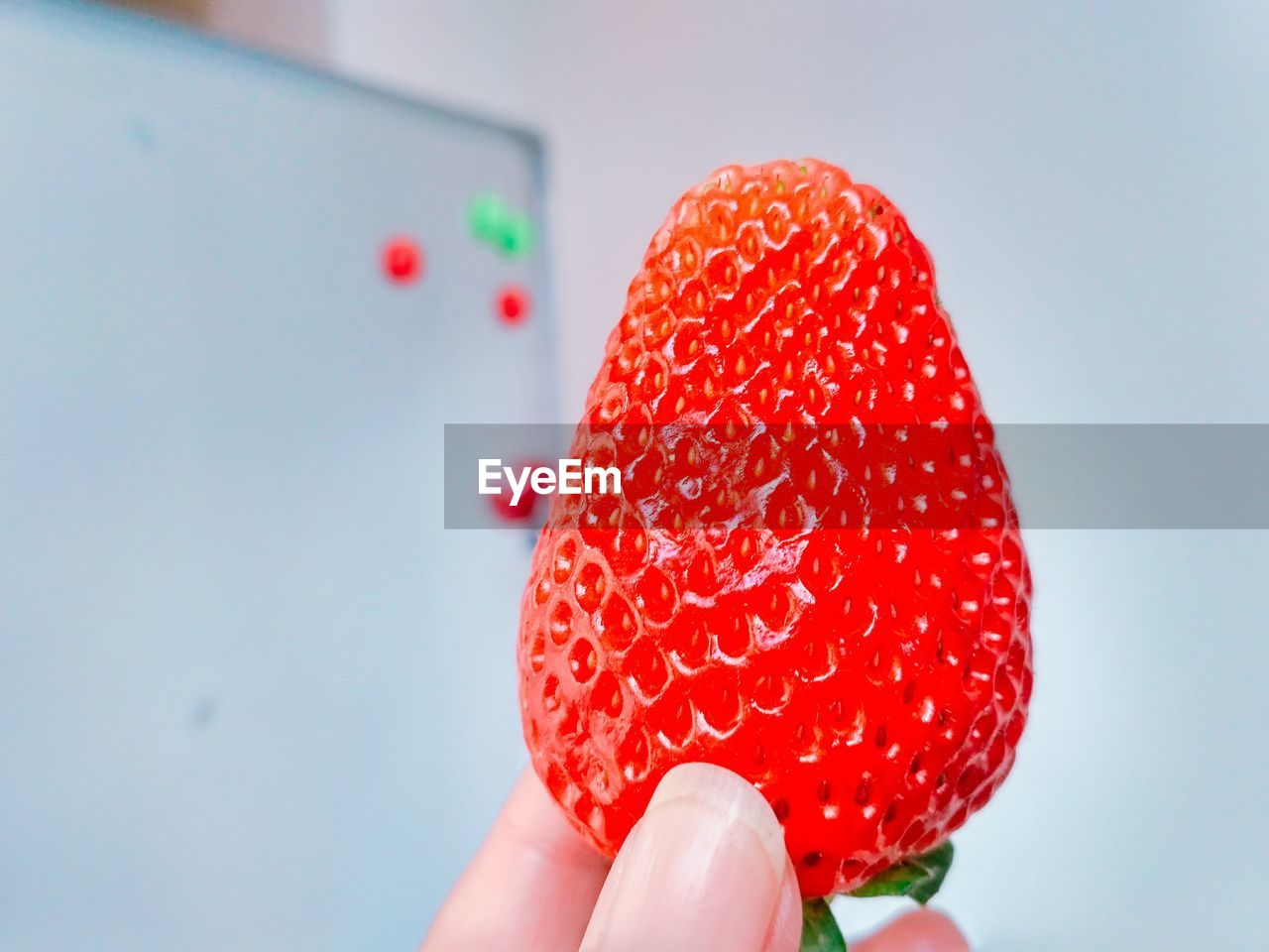 CLOSE-UP OF HAND HOLDING STRAWBERRY ICE CREAM