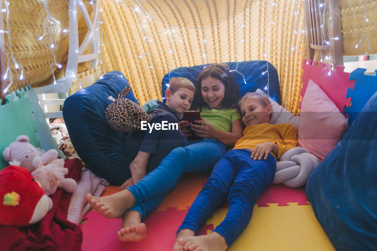 high angle view of mother and daughter sitting on sofa at home