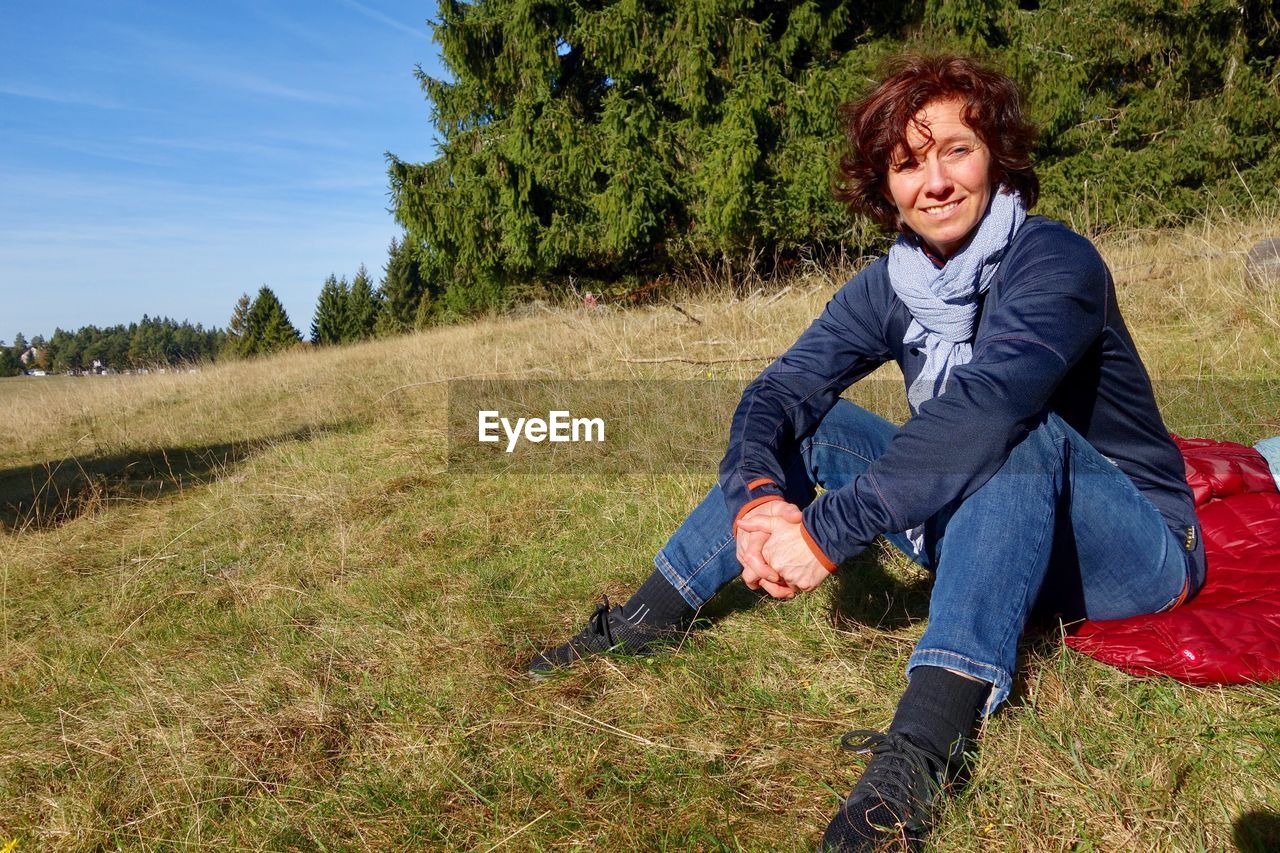 Portrait of woman sitting on grassy field