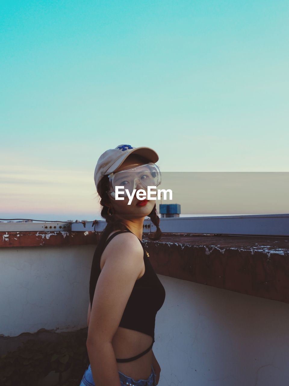 Portrait of young woman standing against sky 