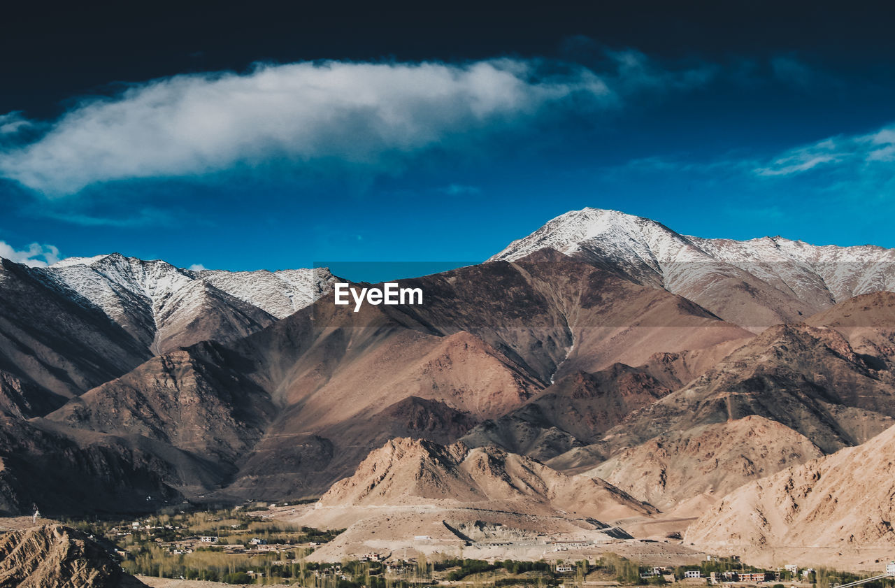 Scenic view of mountains against blue sky