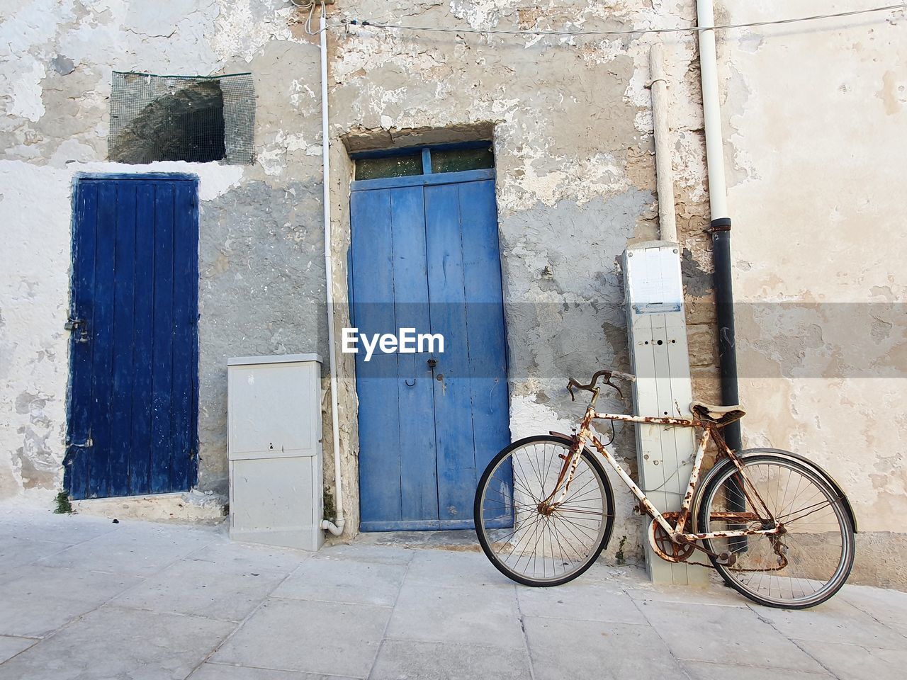 BICYCLE AGAINST DOOR OF BUILDING