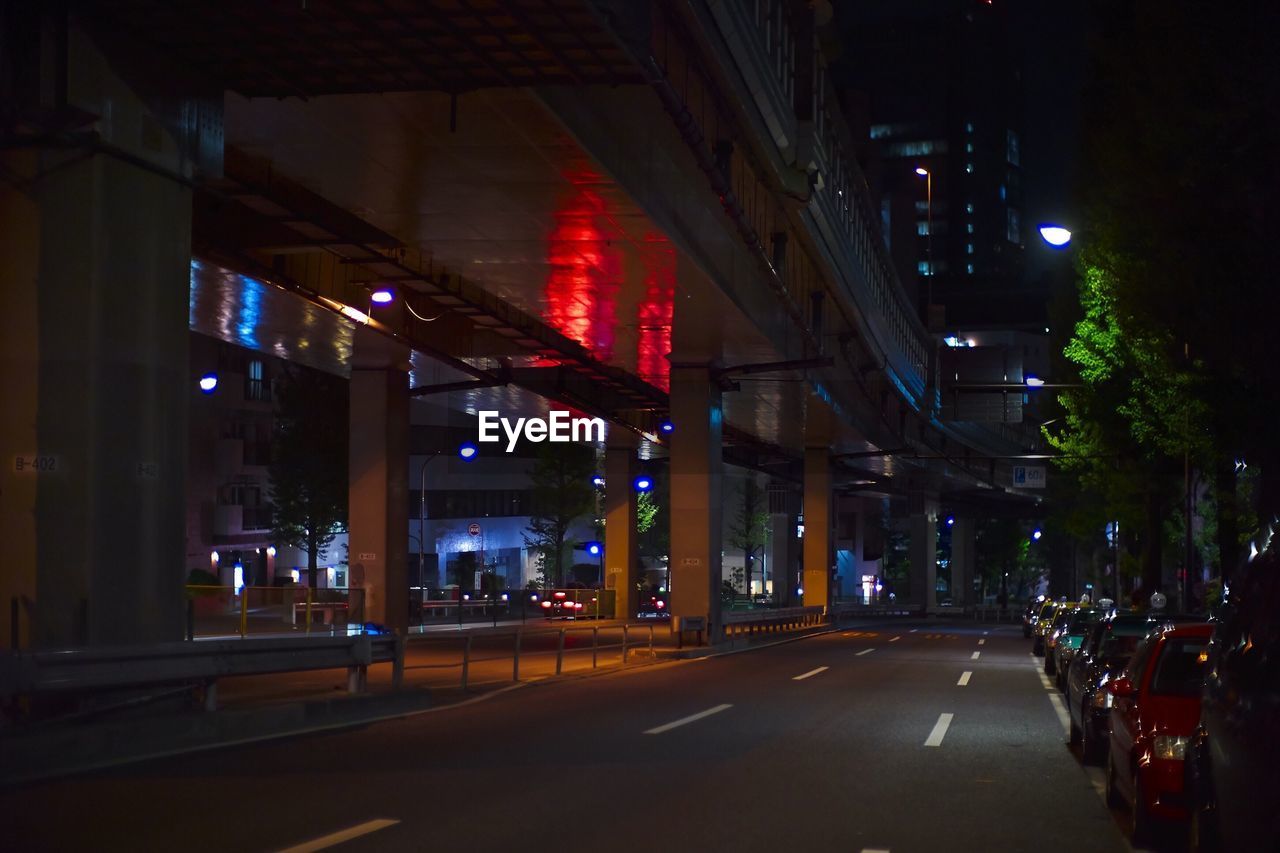 View of city street and bridge at night
