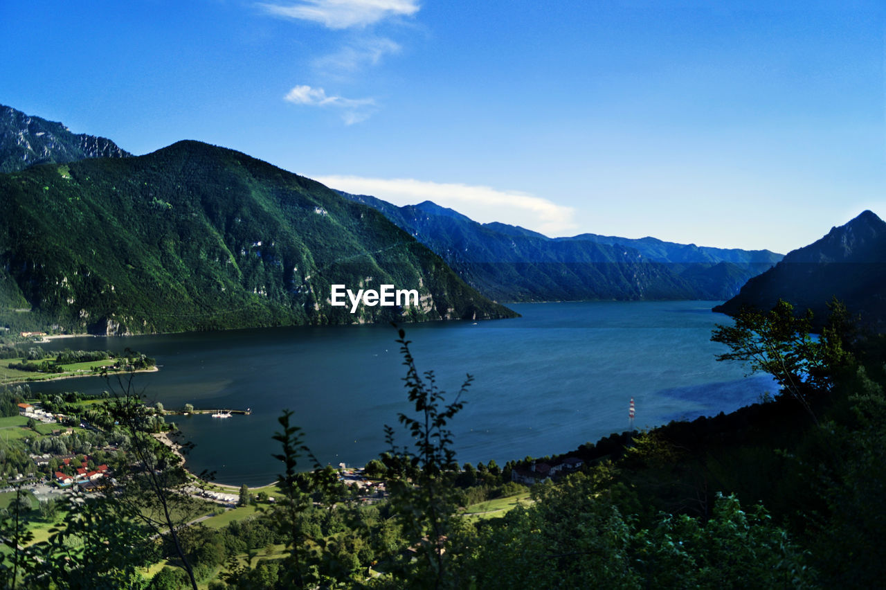 Scenic view of lake and mountains against blue sky