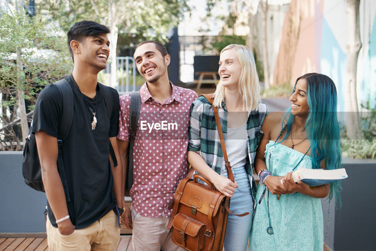 Smiling friends standing in campus