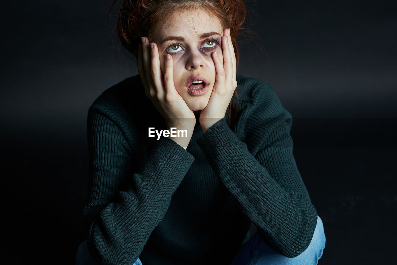 Young woman with bruise on face against background