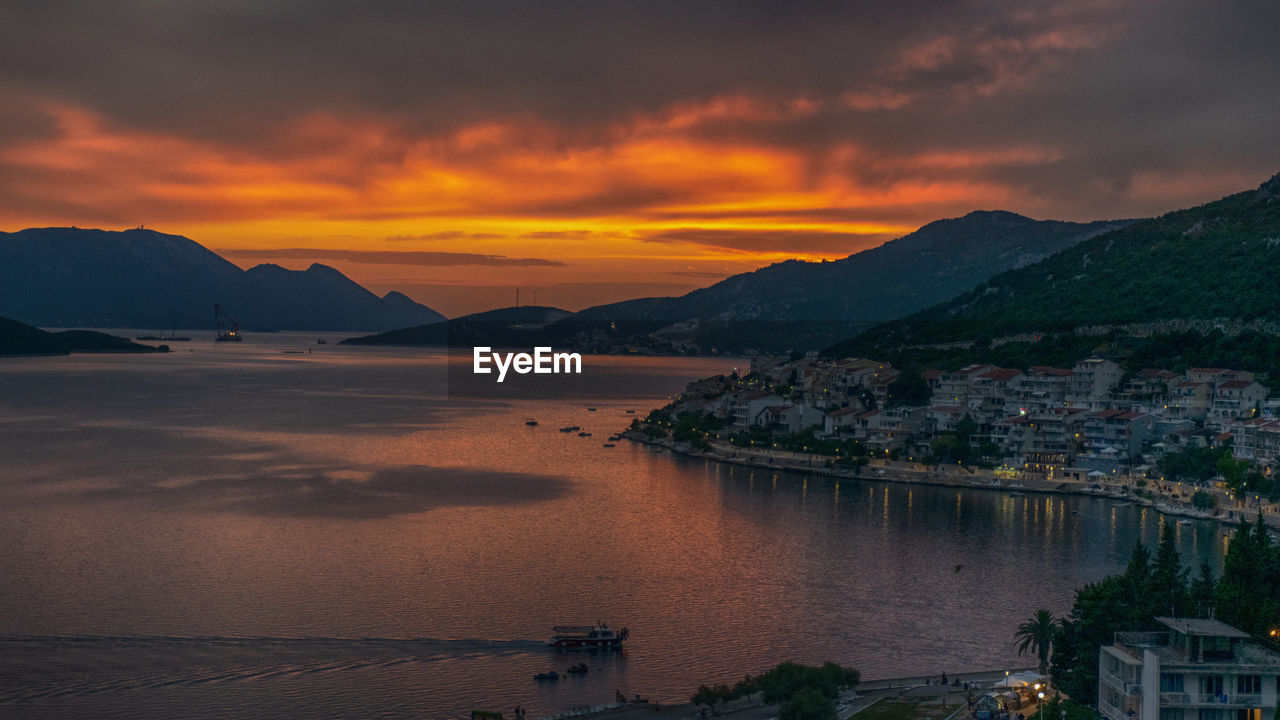 Scenic view of sea and mountains against sky during sunset