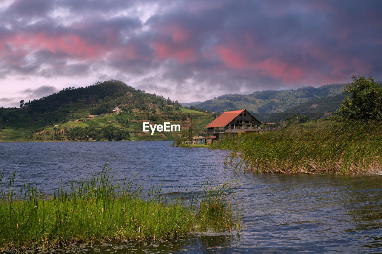 SCENIC VIEW OF LAKE AND HOUSES AGAINST SKY