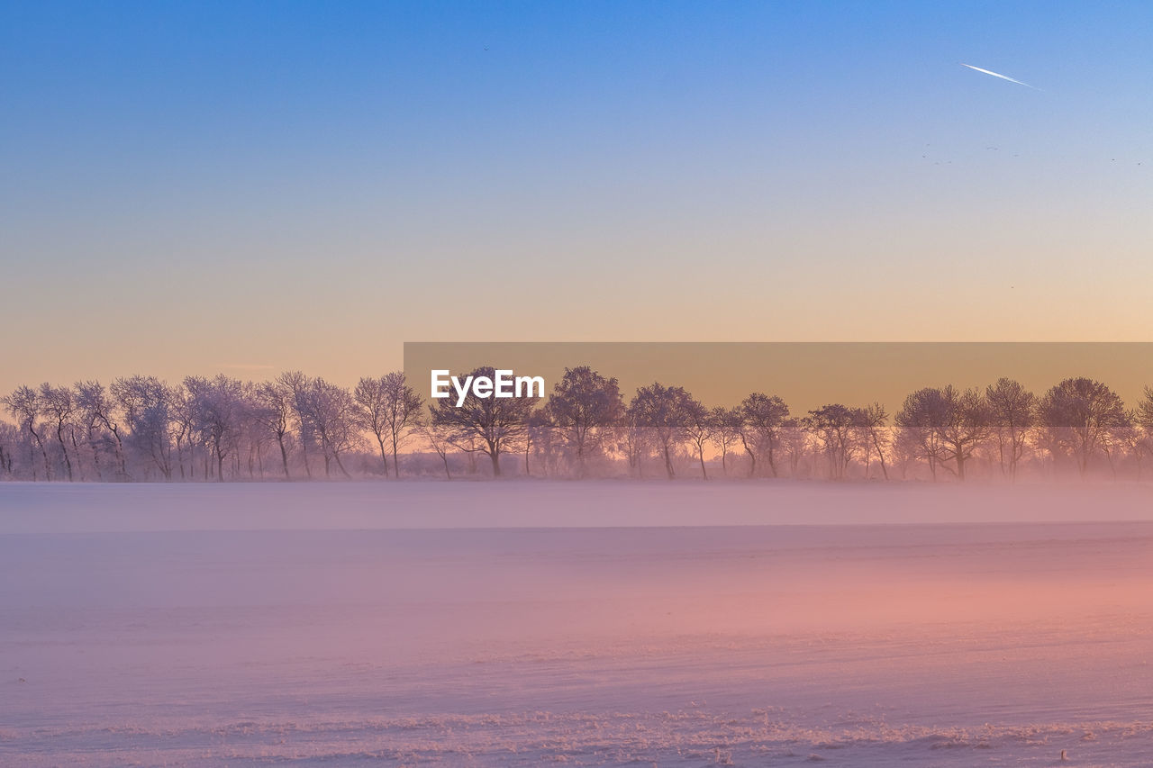 Snow covered landscape against clear sky