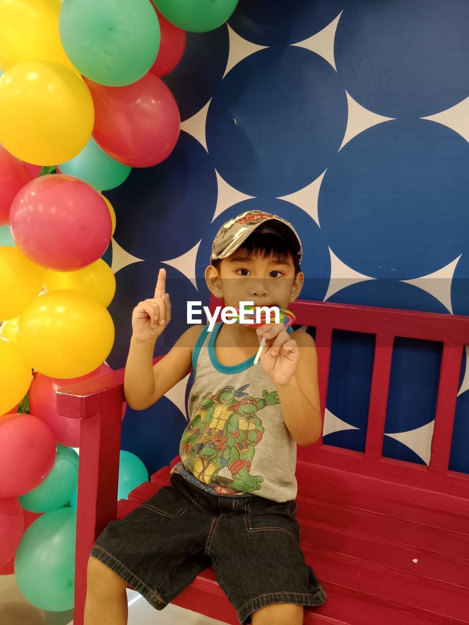 Boy sitting while eating candy 