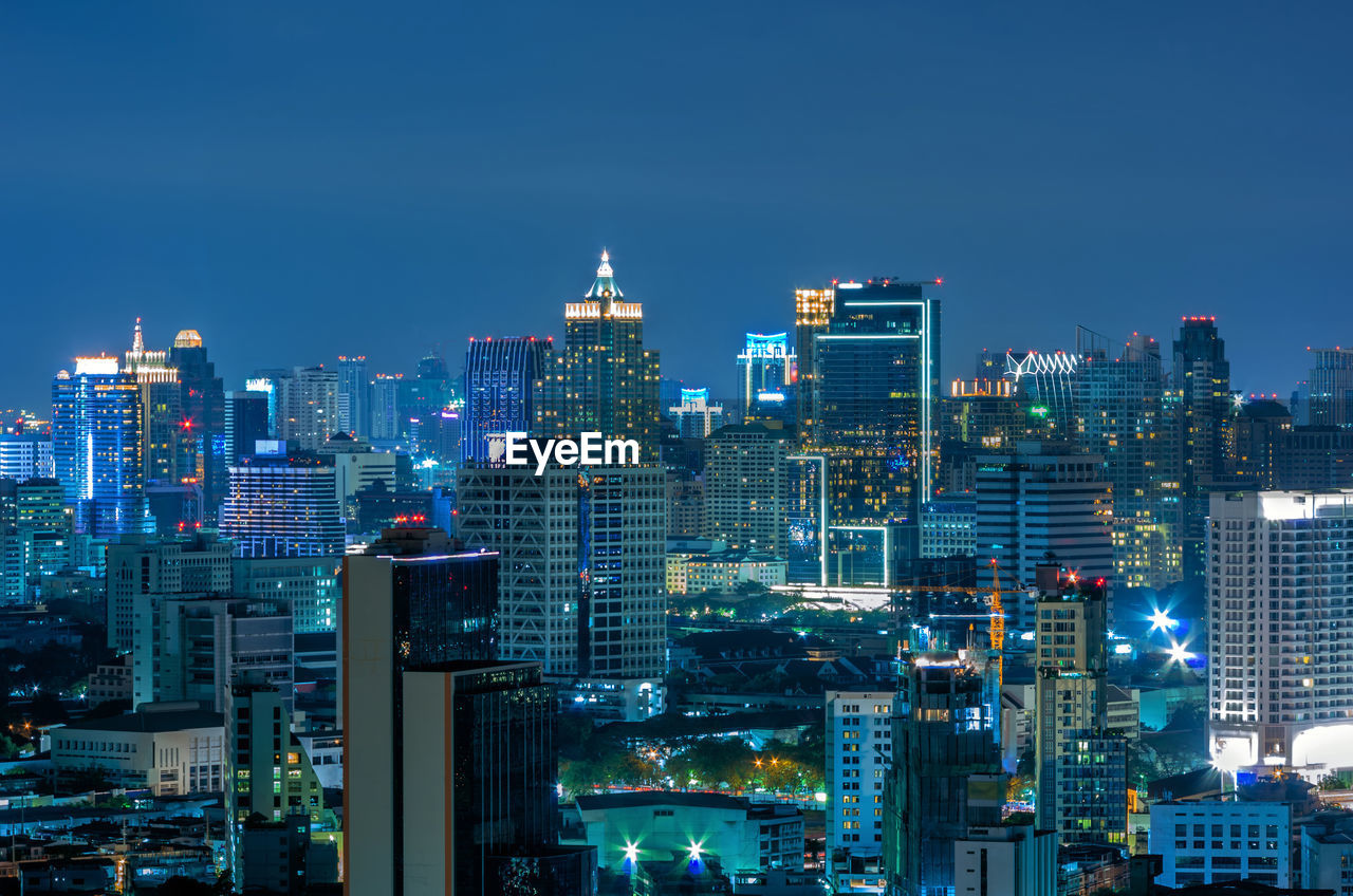 Illuminated cityscape against sky at night