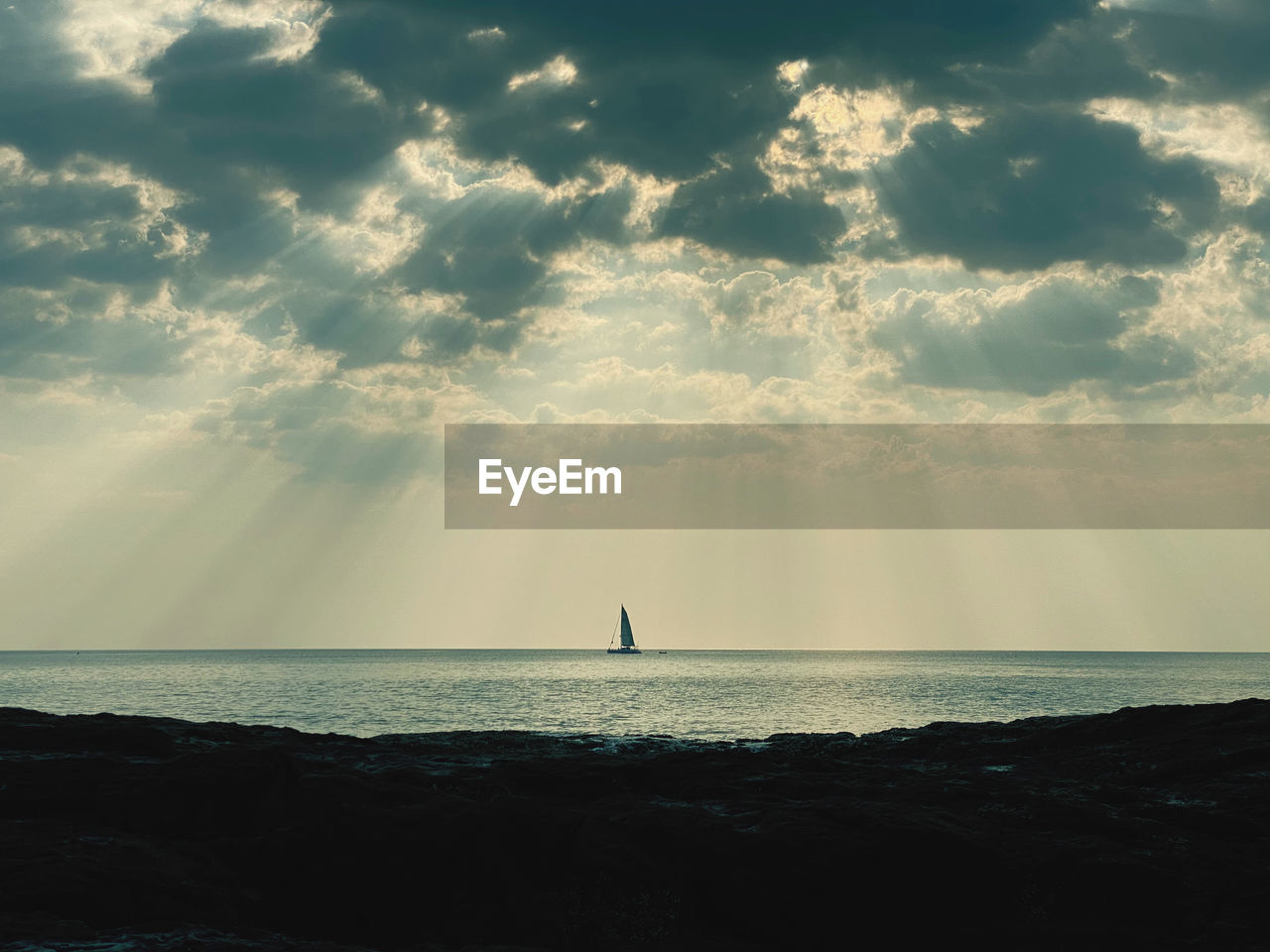 SILHOUETTE OF SAILBOAT ON SEA AGAINST SKY
