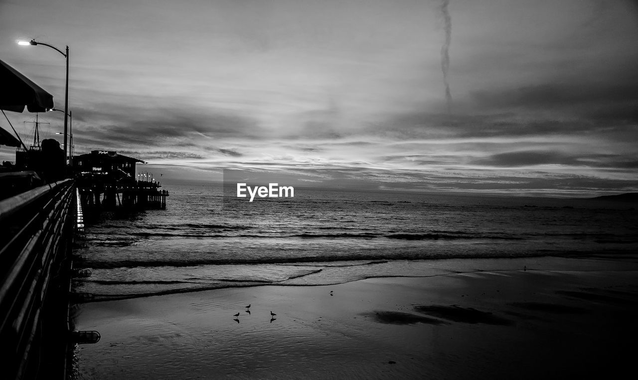 SCENIC VIEW OF BEACH AGAINST CLOUDY SKY