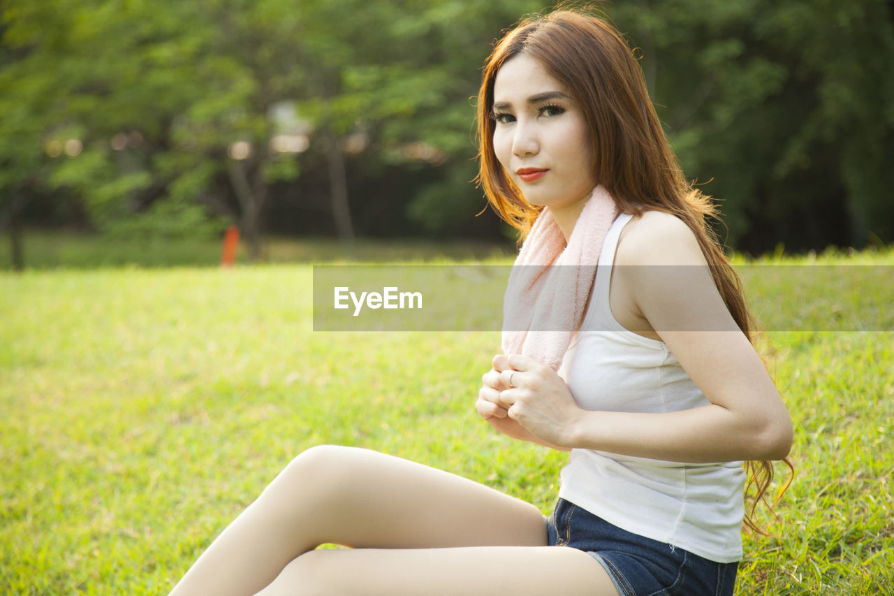 Woman sitting on field at park