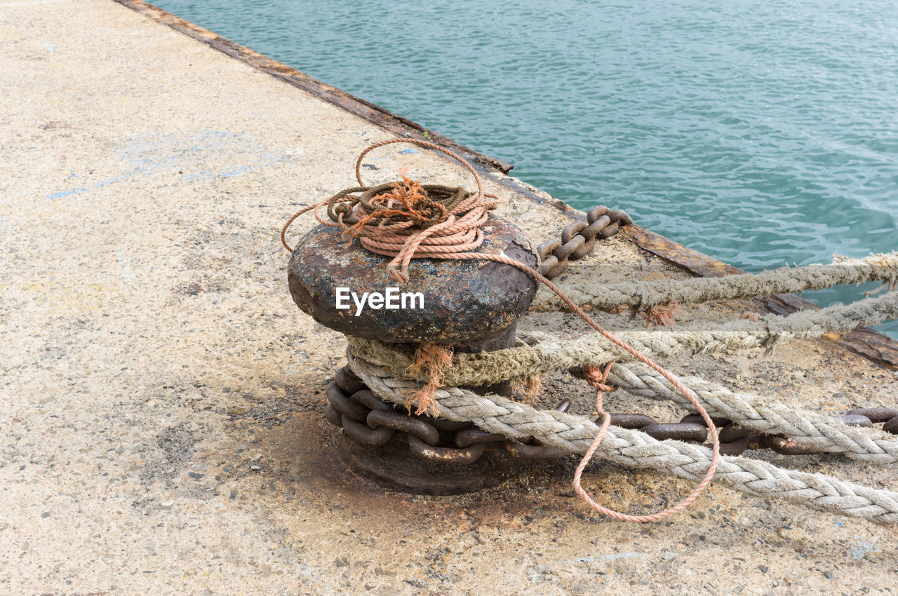 HIGH ANGLE VIEW OF ROPE TIED ON ROCKS