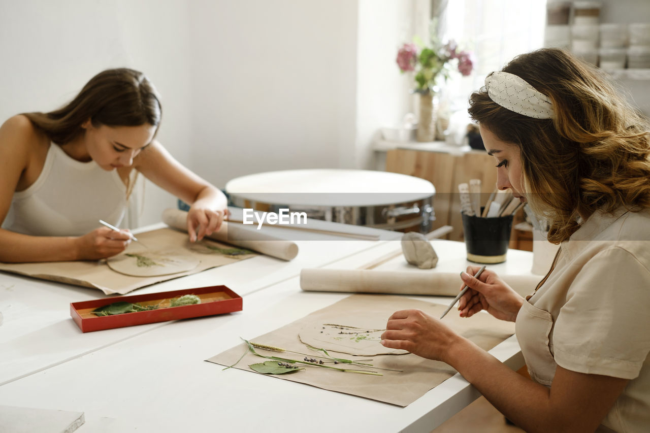 Pottery workshop in studio. people working with clay on the table. adults learning to do ceramic