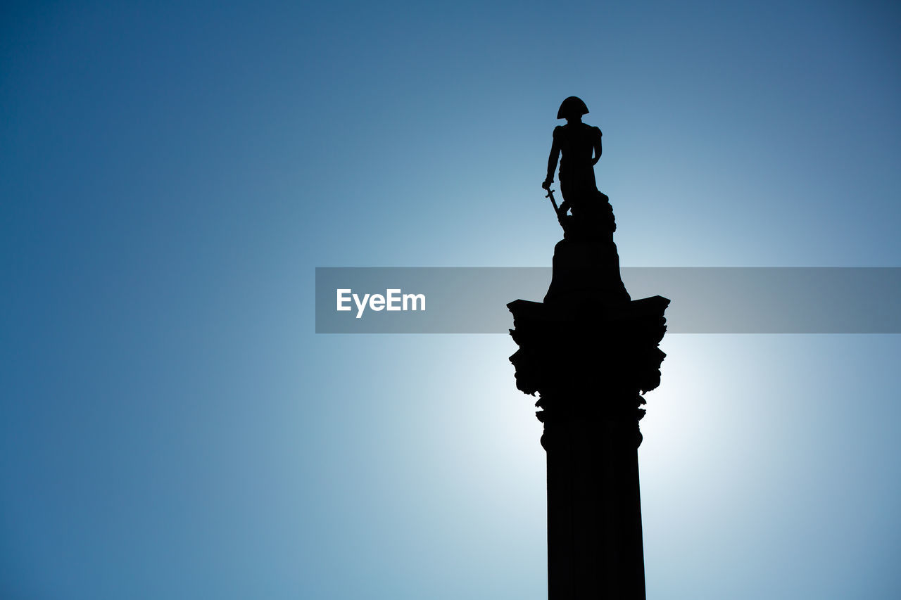 LOW ANGLE VIEW OF STATUE AGAINST BLUE SKY