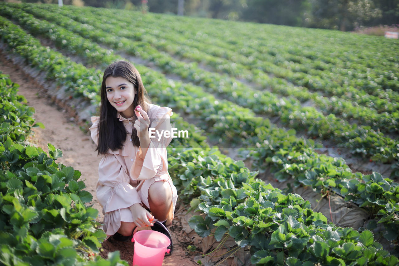 Portrait of smiling young woman standing in farm